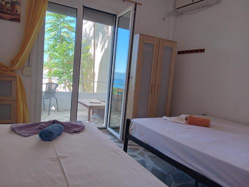 2 łóżka w pokoju z widokiem na ocean w obiekcie Flora's Beach House Your House On The Beach w mieście Amarynthos