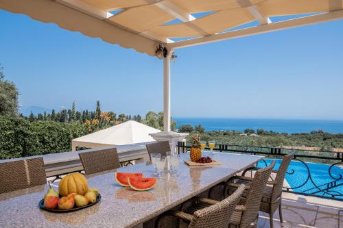 a table with fruit on top of a patio at Frido Luxury Villa with Jacuzzi in Akrotiri