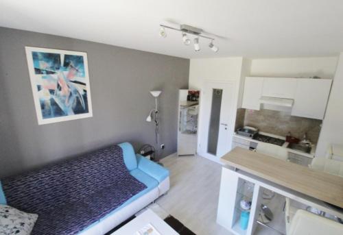 salon z niebieską kanapą i kuchnią w obiekcie Studio Jana Umag w mieście Umag