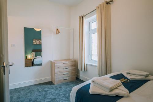 1 dormitorio con cama, ventana y vestidor en Barron House By Horizon Stays en Darlington