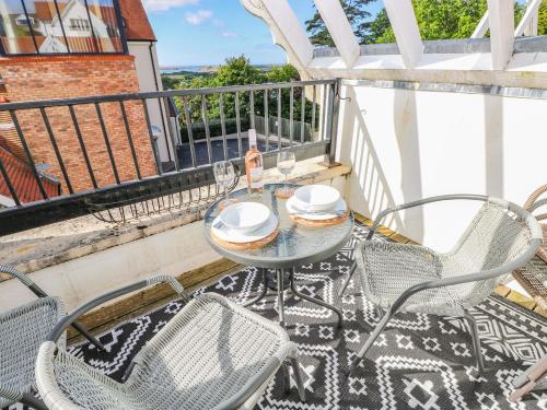 a patio with a table and chairs on a balcony at Puffins in Tenby