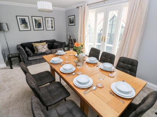 a dining room with a wooden table and chairs at Puffins in Tenby