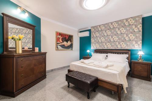 a bedroom with a large bed with a dresser and a painting at Frido Luxury Villa with Jacuzzi in Akrotiri