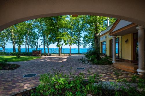 an archway over a brick walkway next to a building at Hotel Anna Villa in Balatonföldvár