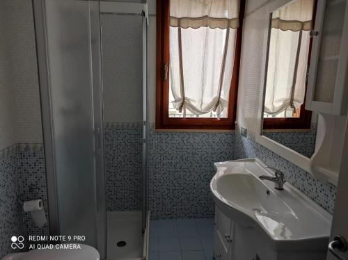 La salle de bains est pourvue d'un lavabo et d'une douche. dans l'établissement APPARTAMENTI RIMINI NEL CUORE, à Rimini