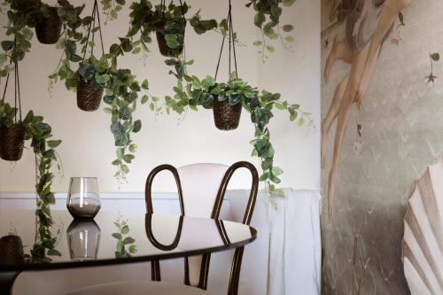 a dining room with plants hanging from the ceiling at La Bella di Lajatico in Laiatico