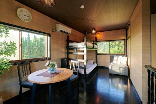 淡路市にあるAwaji Aquamarine Resort #3 - Self Check-In Onlyのテーブルと二段ベッドが備わる客室です。
