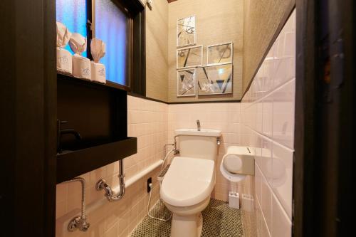 Un pequeño baño con inodoro y ventana. en Awaji Aquamarine Resort #3 BBQ OK! - Self Check-In Only, en Awaji