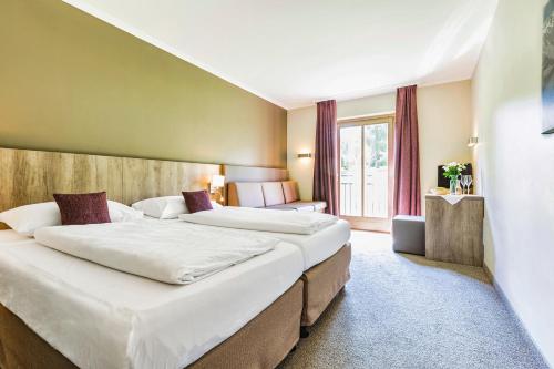 una camera d'albergo con due letti e una finestra di Aldiana Club Ampflwang ad Ampflwang im Hausruckwald