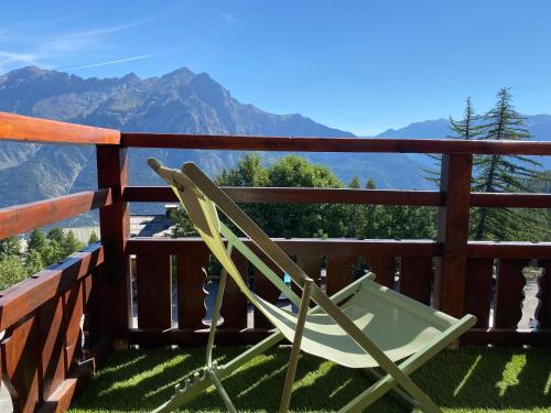 une chaise sur un balcon avec vue sur les montagnes dans l'établissement Appartement Montagne Puy Saint Vincent 1800 - Résidence Dame Blanche 3 étoiles, à Puy-Saint-Vincent