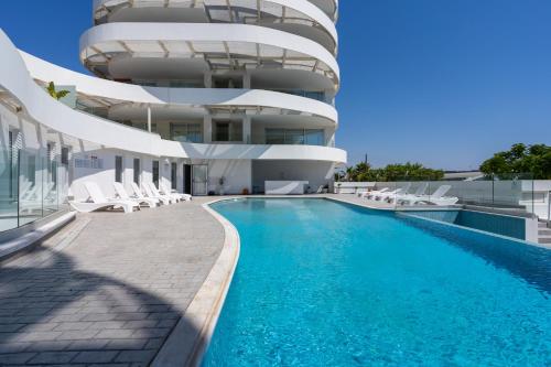 a building with a swimming pool in front of a building at Oyster 1-BR Apt in Larnaca in Larnaca