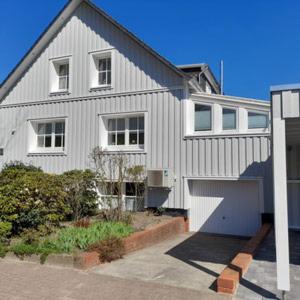 a white house with a garage in front of it at Thoreys Ferienwohnung in Soltau in Soltau