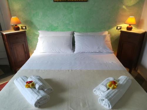 a bedroom with a bed with two towels and two lamps at Dimora Maltese in Morciano di Leuca