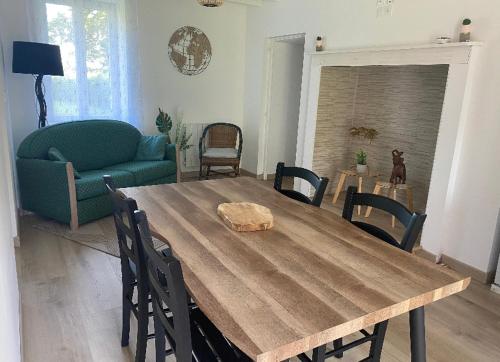 a living room with a wooden table and a couch at Le gîte des Grivots 