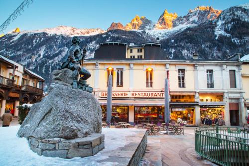 a statue in front of a building with mountains at Dormio Resort Les Portes du Mont Blanc in Vallorcine