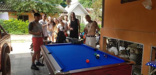 a group of people standing around a pool table at Peace of Love Pai in Pai