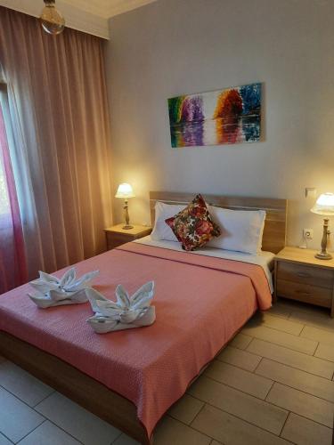 a bedroom with a bed with two white flowers on it at Sevastiani’s Apartments in Skala Kallirachis