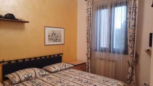 Schlafzimmer mit einem Bett und einem Fenster in der Unterkunft Appartamento Nuccia - Box Auto Gratuito e Biancheria Inclusa in Pietra Ligure