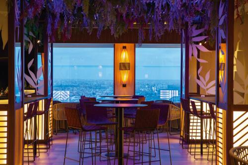 a restaurant with tables and chairs and a view of the city at Riu Plaza España in Madrid