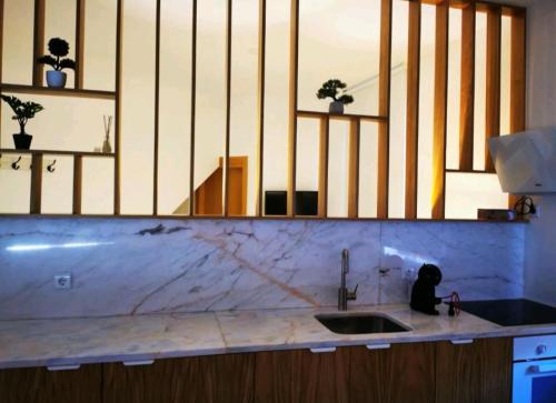 a kitchen counter with a sink and a mirror at Isabel do Couto - casa de charme in Castro Daire