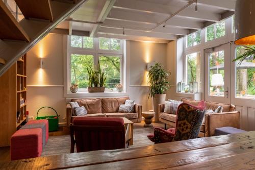 a living room with a lot of furniture and windows at Stayokay Hostel Soest in Soest