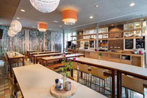 un restaurante con mesas y sillas y un bar en Stayokay Hostel Soest en Soest