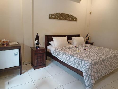 1 dormitorio con 1 cama y TV en Rumah Askara, en Lovina
