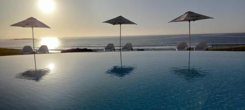 ein Pool mit Sonnenschirmen im Wasser in der Unterkunft Diaz Hotel and Resort in Mossel Bay