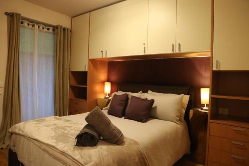 Un dormitorio con una cama grande con una toalla. en Italian Apartment with Hot Tub en Arabba