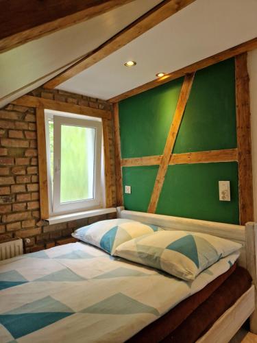 a bedroom with a large bed with a green wall at TOBY 2 minuty do plaży nah am strand in Międzyzdroje