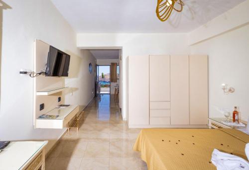 a living room with a bed and a tv at FabView Studio Apartments in Panormos Rethymno