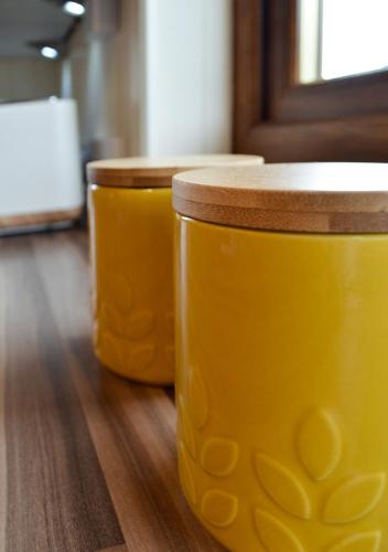 two jars of yellow paint sitting on a wooden floor at The Tower, Moray Firth Holiday Home in Kinloss
