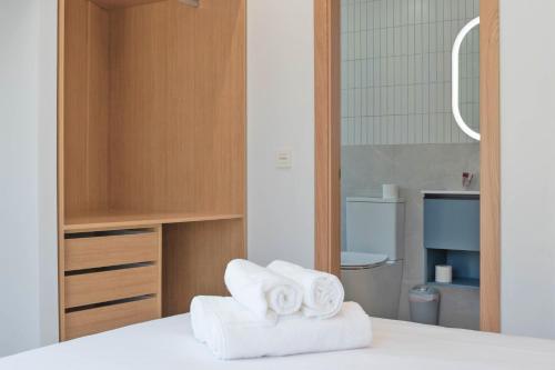 a pile of towels sitting on top of a bed at Rio Salado Conil Hostal in Conil de la Frontera