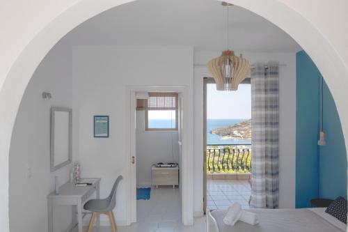 Pefkides Aegina Boutique Apartments في أغيا مارينا ايجينا: غرفة بسرير وإطلالة على المحيط
