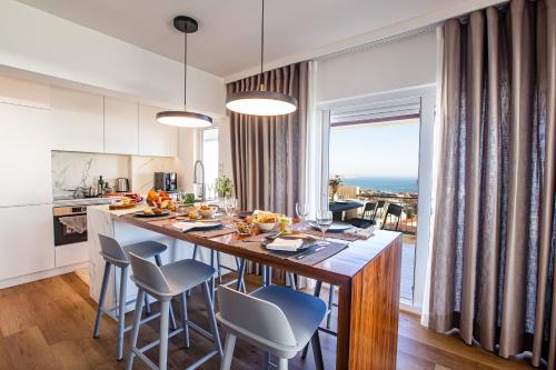 una cocina con una gran isla de cocina con sillas en Equador Penthouse by Olala Homes, en Cascais