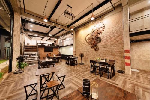a restaurant with tables and chairs and a brick wall at The Entaneer Poshtel in Chiang Mai