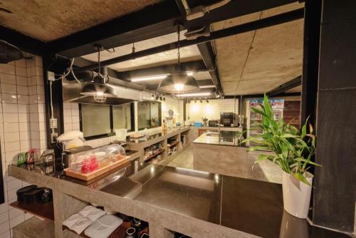 a large kitchen with a large stainless steel counter at The Entaneer Poshtel in Chiang Mai