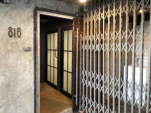 an iron gate in a room with a door at The Entaneer Poshtel in Chiang Mai