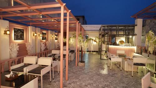 a restaurant with white tables and chairs on a balcony at Hotel Nikhil Regency in Bhilai