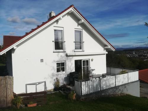 a white house with a fence at Einzigartiger Panoramablick zur Schwäbische Alb in Altenriet