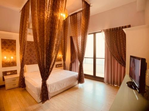 Schlafzimmer mit einem Bett mit Vorhängen und einem TV in der Unterkunft 居歇座民宿 in Magong