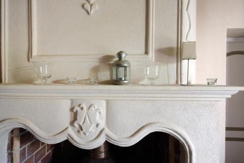 - une cheminée avec deux verres et une bougie dans l'établissement La Petite Maison - Mas des Sous Bois, à Ventabren