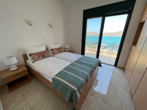 a bedroom with a bed with a view of the ocean at Villa Helios in Elounda