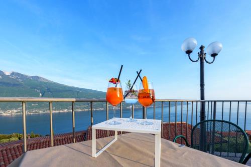 a table with two drinks on top of a balcony at Residence Ruculì - Ruculì Hospitality in Tignale