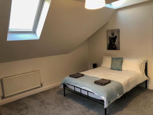a bedroom with a bed in a attic with a window at Surrey - Private House with Garden & Parking 13 in Wentworth