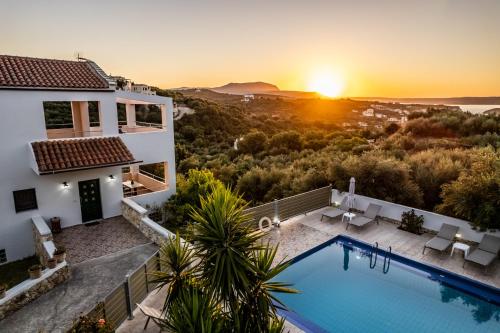 a villa with a swimming pool at sunset at Villas Almyrida in Almyrida