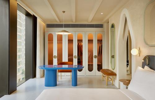a blue table in a room with a bed at The Standard, Bangkok Mahanakhon in Bangkok