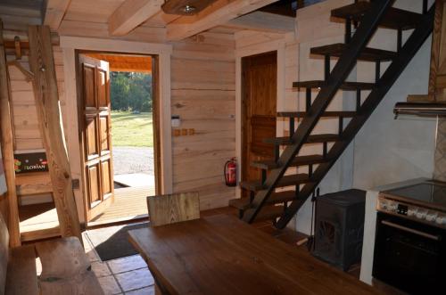 Mägede的住宿－Tõrvaaugu Holiday Homes，小木屋设有木桌和楼梯