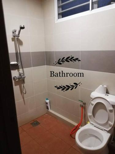 a bathroom with a toilet with the word bathroom on the wall at Sakura Homestay 4 bedrooms 14pax- Eaton Hills Padang Kerbau Miri in Miri