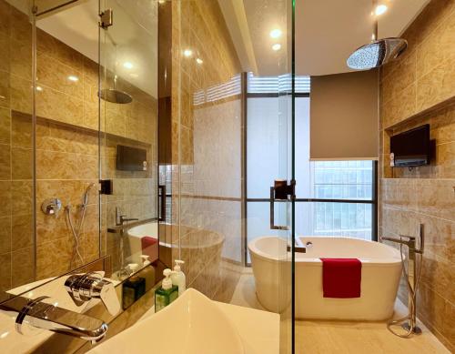 une salle de bain avec une baignoire, un lavabo et une douche dans l'établissement Nana's at Dorsett Residence Bukit Bintang, à Kuala Lumpur